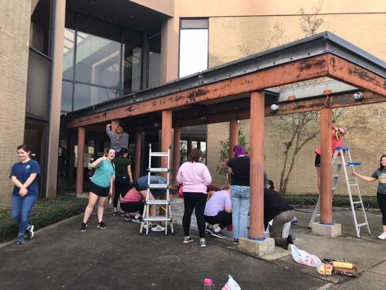 Group of people repainting a community hospital