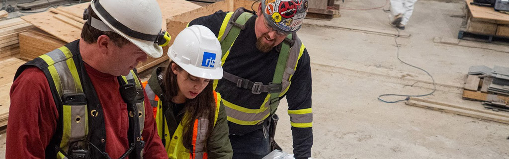 Three workers discussing plans