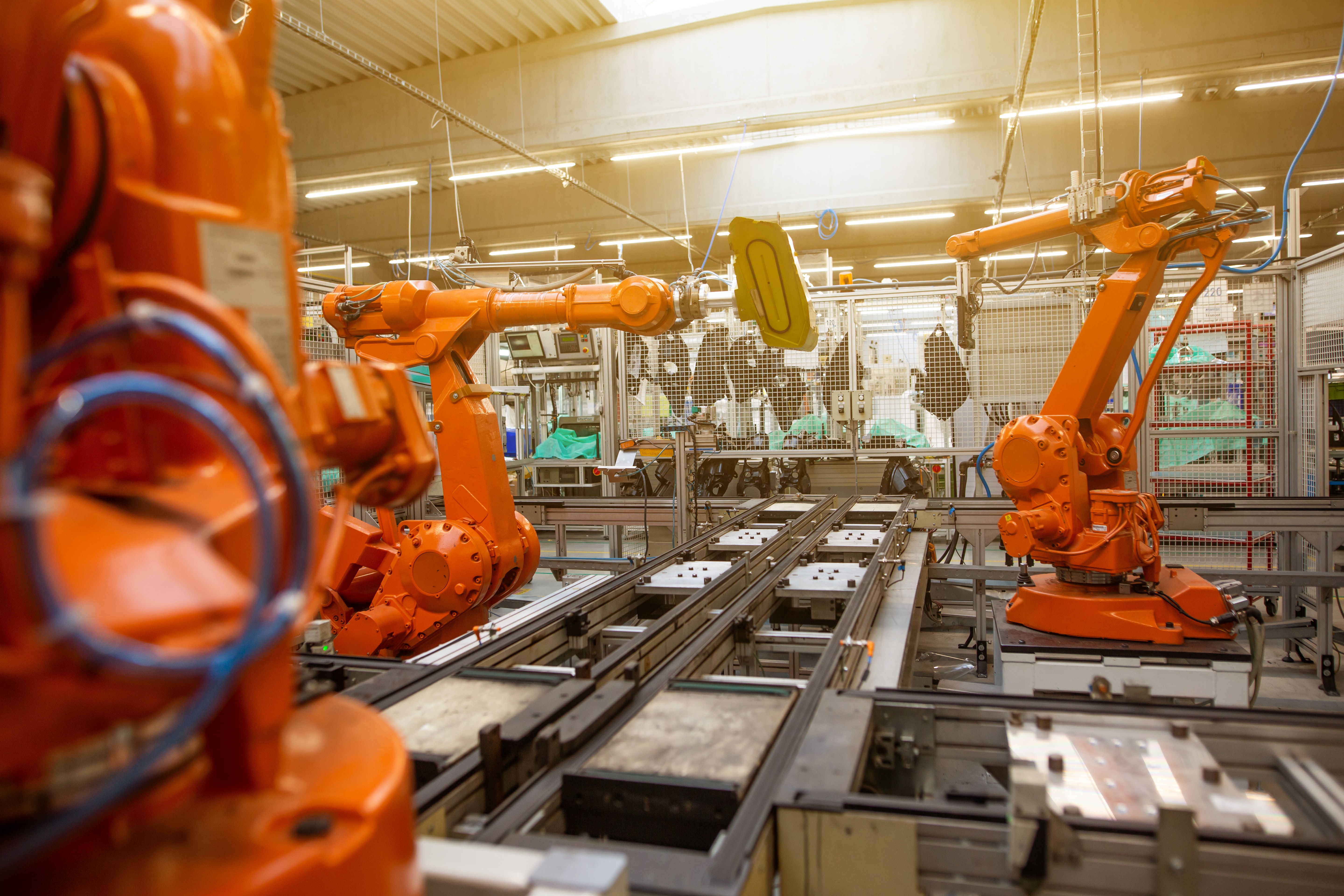 orange robot arms in a factory