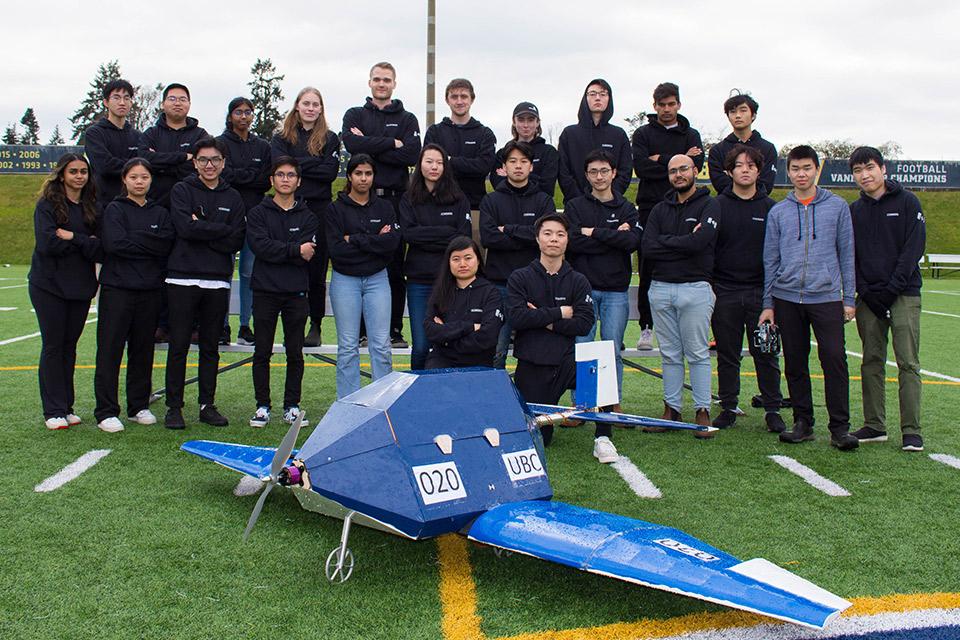 AeroDesign team in front of their aircraft on a football field