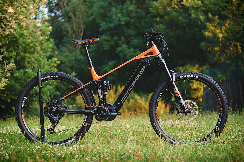 Mountain bike with a black and orange frame in the grass