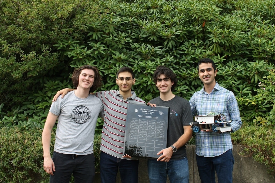 Four students in the winning team hold a plaque and their autonomous robot "Sharp"