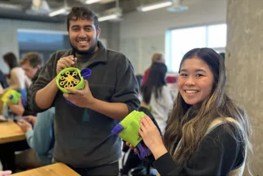 Two team members each holding a gadget.