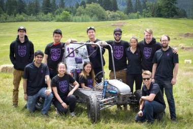 UBC Baja student design team with their vehicle in a field