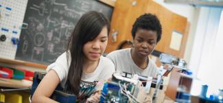 Two UBC Engineering Physics students preparing for the annual summer robot competition.
