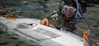 Team member in the water with submarine.