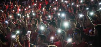 Students shining their flash lights at an event