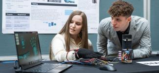 Two students watching a screen pick up data