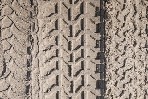 Vertical rubber tire tracks in sand