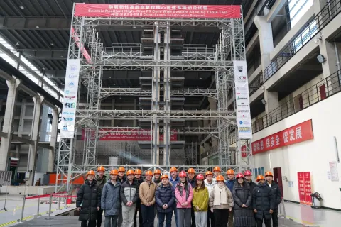 Dr. Tony Yang and team in front of the tower model, surrounded by scaffolding