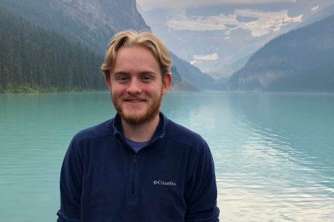 Cameron, smiling, in front of beautiful lakes and mountains in Banff, Alberta