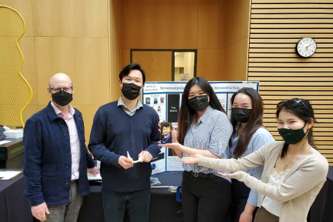 Team members standing around their project.