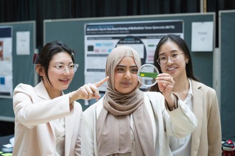 3 girls standing and observing a petri dish