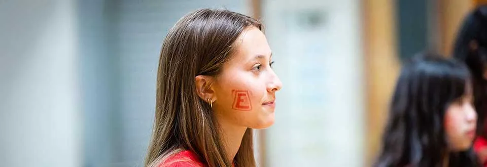 Female engineering student with a temporary E tattoo on her cheek.