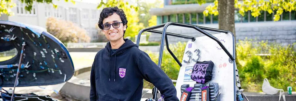 UBC Baja team member standing in front of the team vehicle