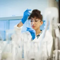 Student in a lab holding a mini Erlenmeyer flask.